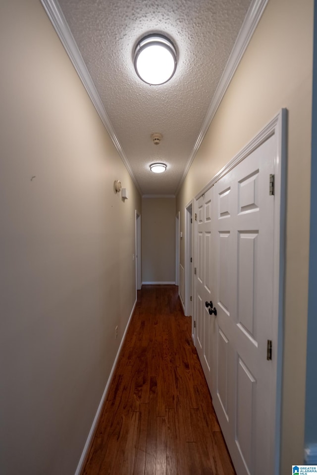 hall featuring ornamental molding, dark hardwood / wood-style floors, and a textured ceiling