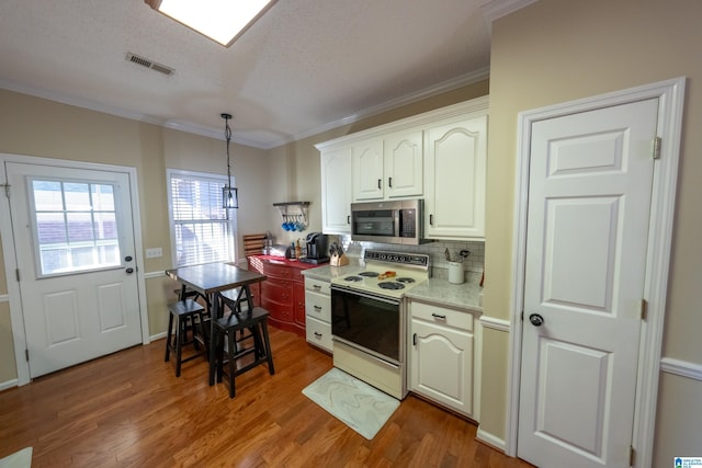 kitchen featuring white electric range, tasteful backsplash, wood-type flooring, ornamental molding, and decorative light fixtures