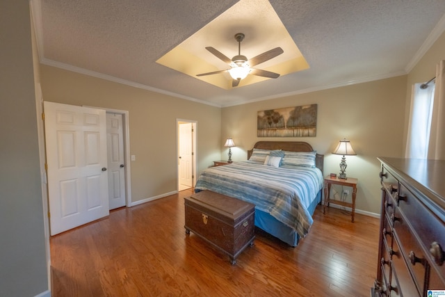 bedroom with crown molding, hardwood / wood-style floors, ceiling fan, and a textured ceiling