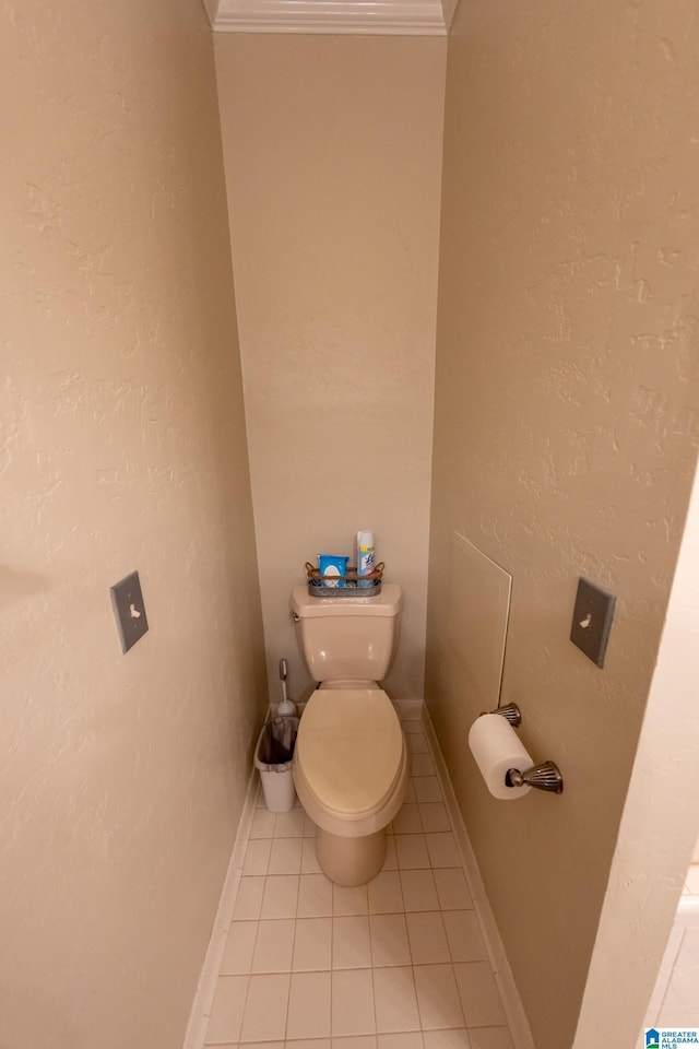 bathroom featuring ornamental molding, toilet, and tile patterned flooring