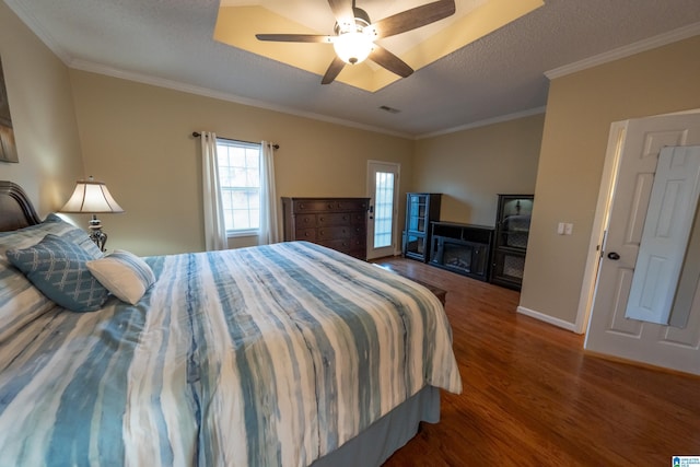 bedroom with hardwood / wood-style flooring, ceiling fan, crown molding, and a textured ceiling