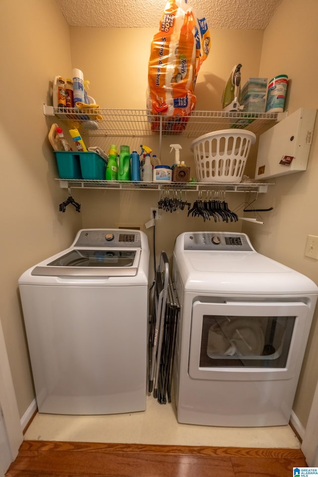 laundry area with a textured ceiling and washer and clothes dryer