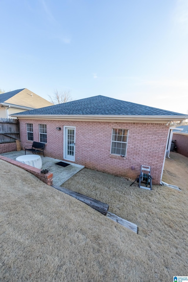 back of house featuring a patio area and a lawn