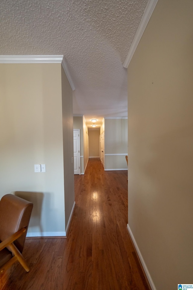 hallway with crown molding, wood-type flooring, and a textured ceiling