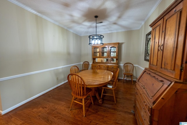 dining area with ornamental molding, dark hardwood / wood-style floors, and a textured ceiling