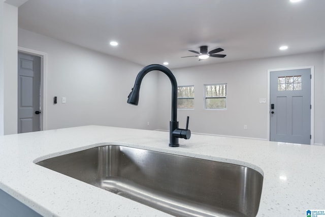 room details with light stone countertops, sink, and ceiling fan