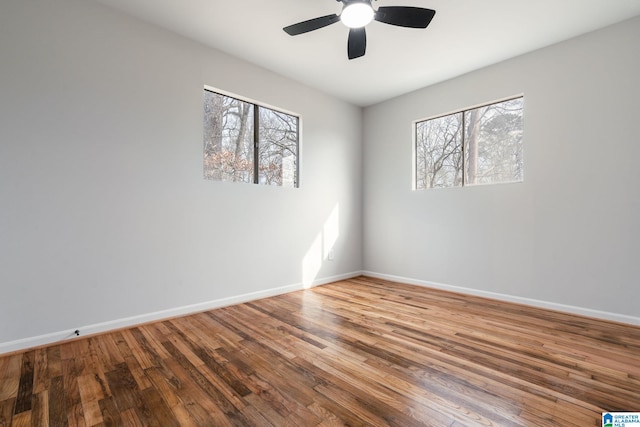 unfurnished room with a healthy amount of sunlight, hardwood / wood-style floors, and ceiling fan