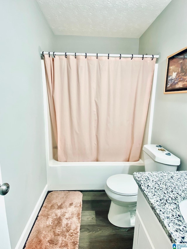 full bathroom with shower / tub combo with curtain, hardwood / wood-style flooring, vanity, toilet, and a textured ceiling