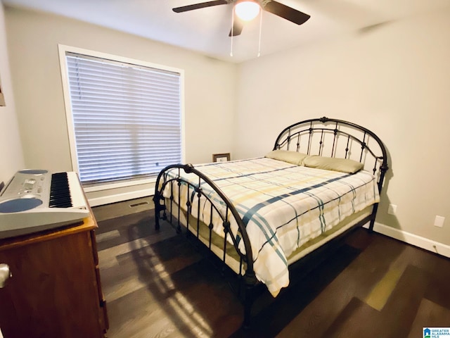 bedroom with dark hardwood / wood-style floors and ceiling fan