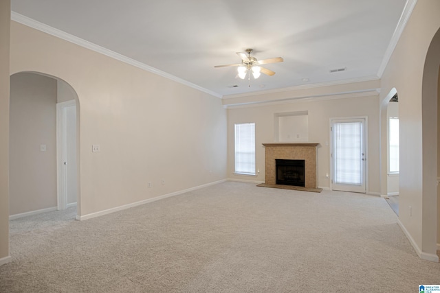 unfurnished living room featuring crown molding, plenty of natural light, and light carpet