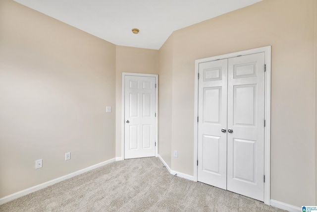 unfurnished bedroom with light carpet and a closet