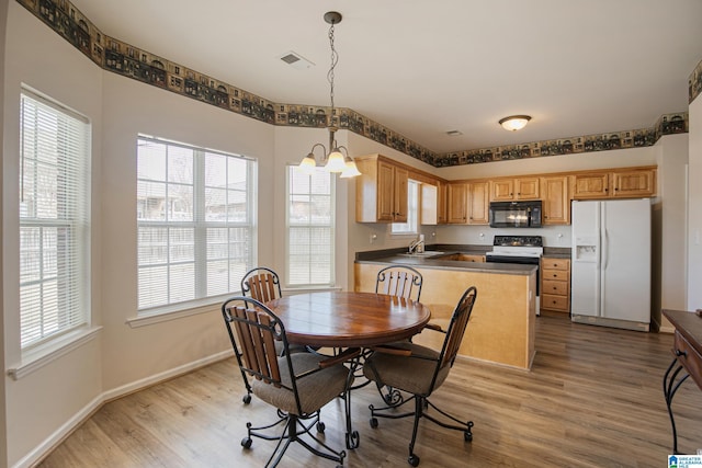 dining area featuring a chandelier, sink, and light wood-type flooring