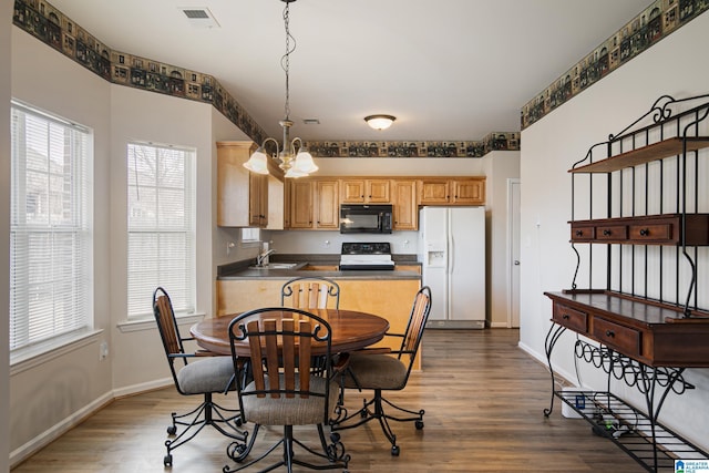 kitchen featuring sink, decorative light fixtures, range with electric stovetop, hardwood / wood-style flooring, and white refrigerator with ice dispenser