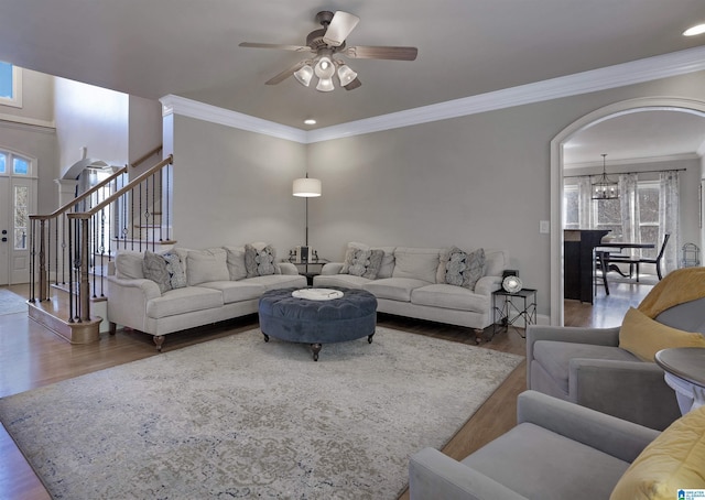 living room featuring wood-type flooring, plenty of natural light, and crown molding