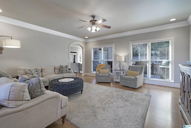 living room with crown molding, ceiling fan, and light hardwood / wood-style flooring