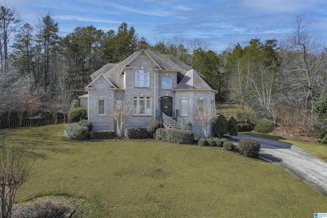 traditional home featuring concrete driveway and a front yard