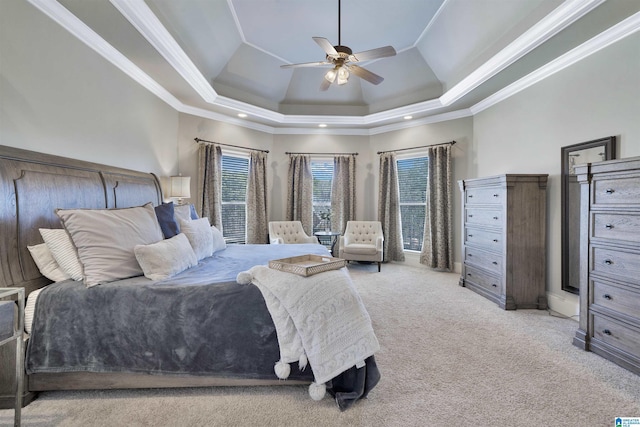 carpeted bedroom with crown molding, ceiling fan, and a tray ceiling