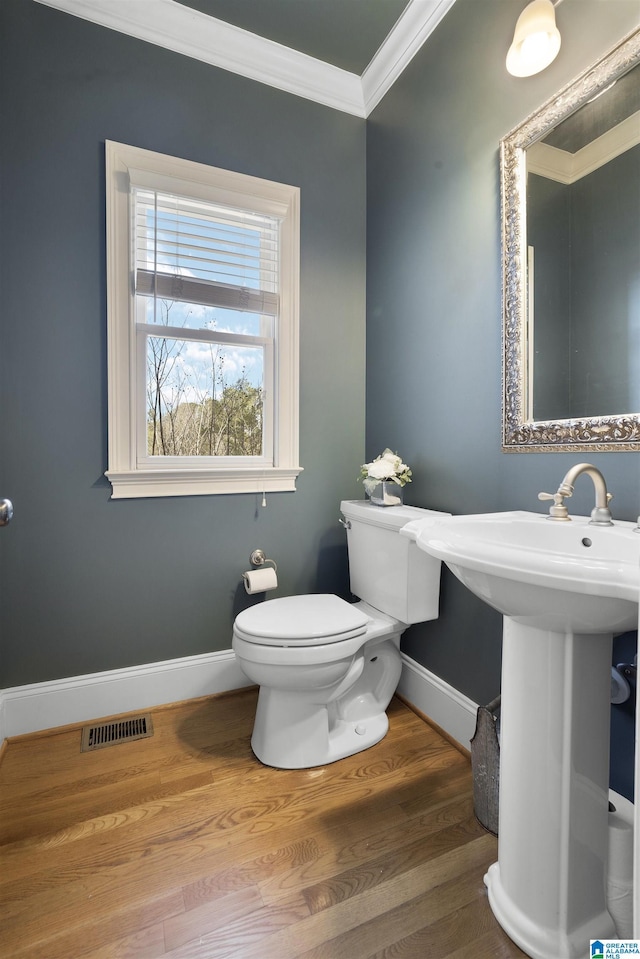 bathroom with crown molding, wood-type flooring, and toilet