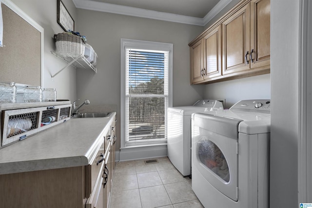 washroom featuring a wealth of natural light, sink, cabinets, light tile patterned floors, and independent washer and dryer