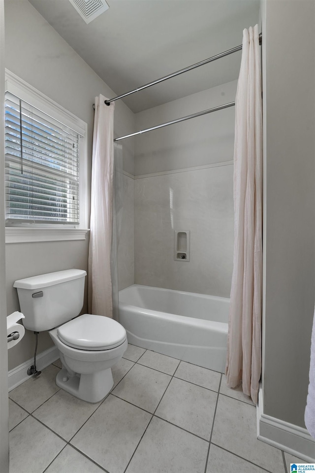 bathroom featuring tile patterned flooring, shower / bath combo, and toilet