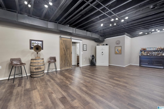 basement featuring dark wood-type flooring and a barn door