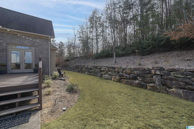 view of yard with a wooden deck and french doors