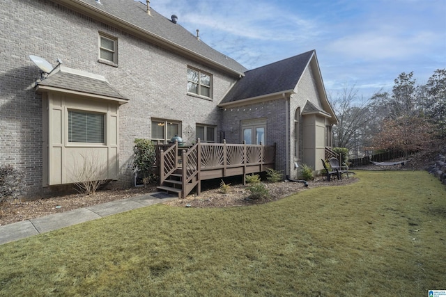 back of property with a wooden deck and a yard