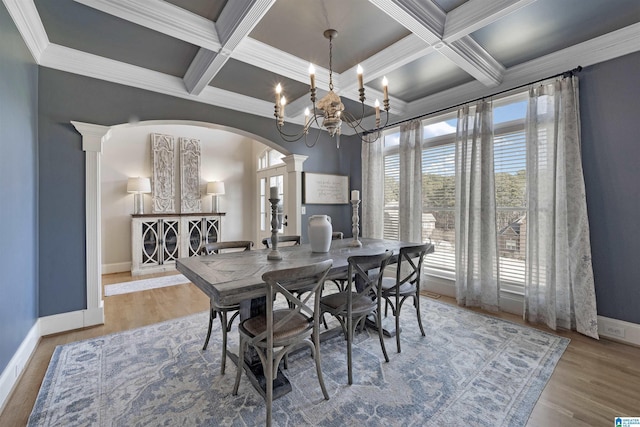 dining room with ornate columns, wood-type flooring, ornamental molding, coffered ceiling, and beam ceiling