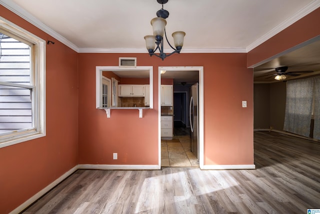 unfurnished dining area with crown molding, ceiling fan with notable chandelier, and light hardwood / wood-style floors