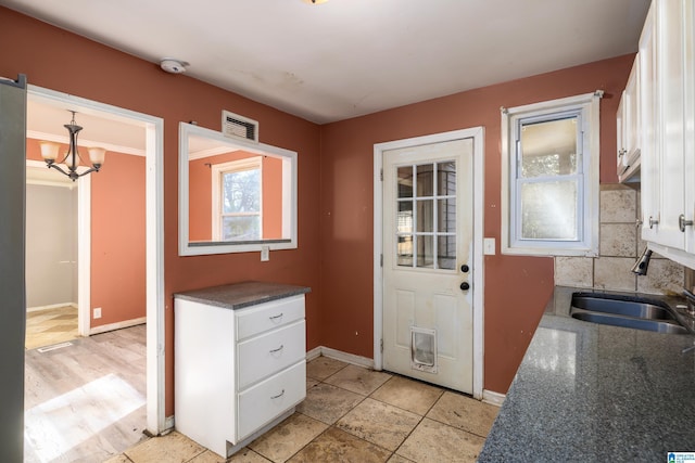 doorway to outside featuring sink and a chandelier