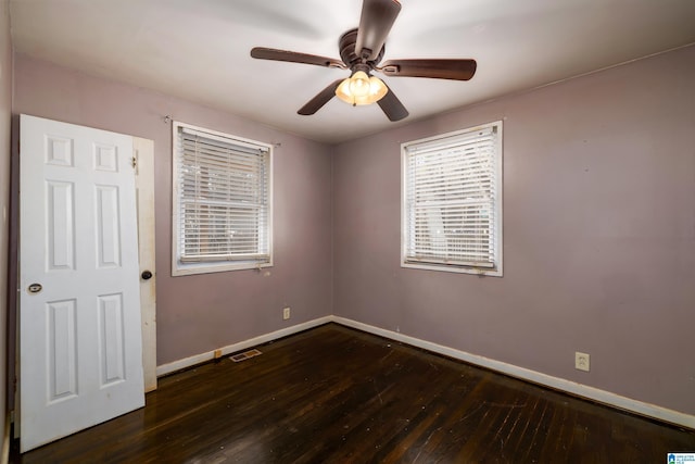 empty room with dark wood-type flooring and ceiling fan