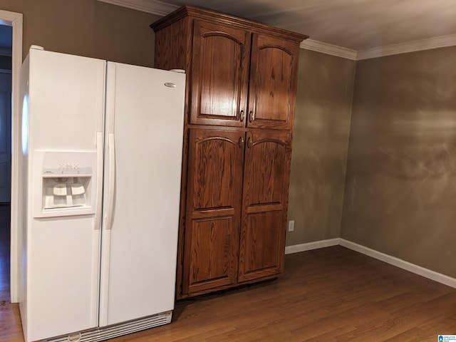 kitchen featuring ornamental molding, white fridge with ice dispenser, and dark hardwood / wood-style flooring