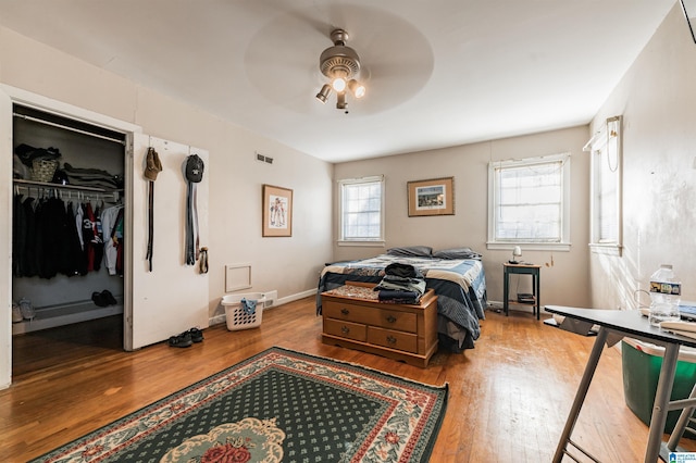 bedroom with ceiling fan, wood-type flooring, and a closet