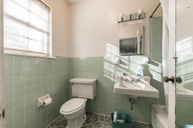 bathroom with tile patterned flooring, sink, tile walls, and toilet