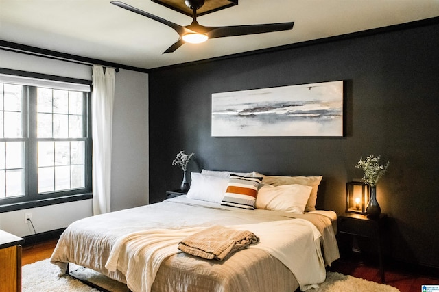 bedroom featuring multiple windows, wood-type flooring, and ceiling fan