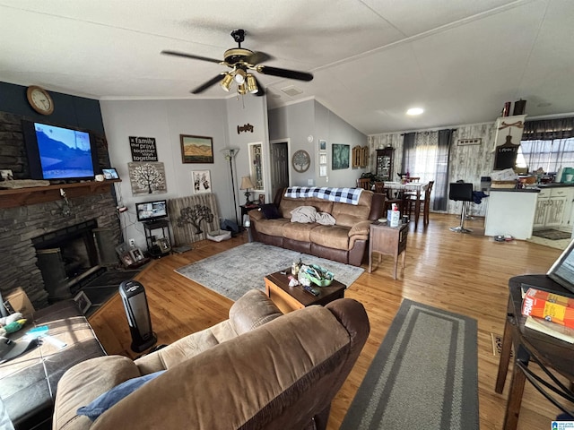 living room with a fireplace, vaulted ceiling, wood-type flooring, and ceiling fan