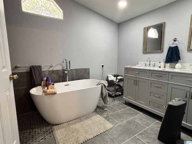 bathroom featuring vanity, a bathtub, and lofted ceiling