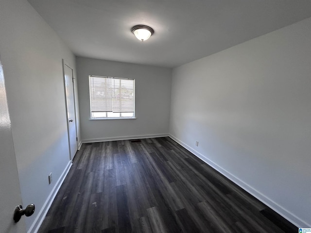 spare room featuring dark wood-type flooring