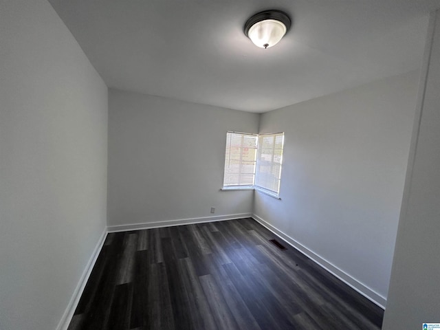 spare room featuring dark wood-type flooring