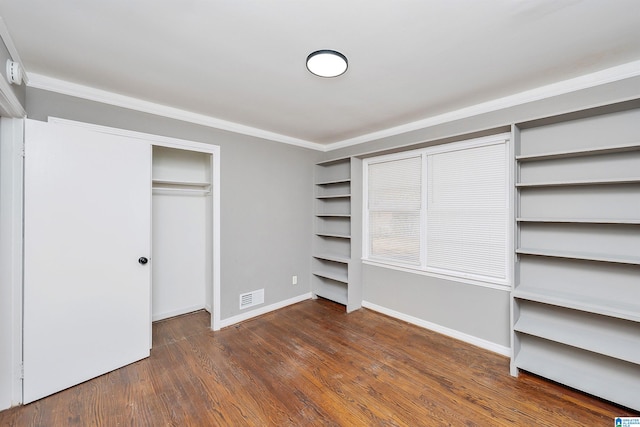 unfurnished bedroom featuring crown molding and dark wood-type flooring