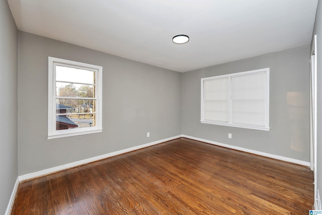 unfurnished room with dark hardwood / wood-style flooring