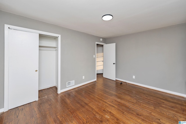 unfurnished bedroom featuring dark wood-type flooring and a closet