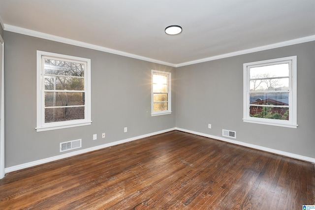 spare room with ornamental molding and dark hardwood / wood-style flooring