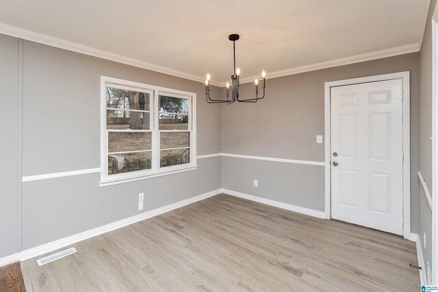 unfurnished dining area featuring ornamental molding, a chandelier, and hardwood / wood-style floors