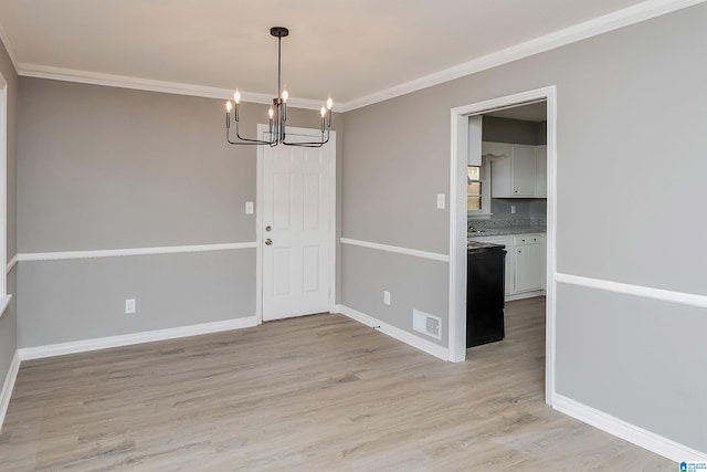 unfurnished dining area featuring a notable chandelier, crown molding, and light hardwood / wood-style flooring