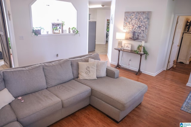 living room with wood-type flooring and washer / clothes dryer