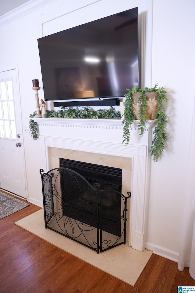 interior details featuring crown molding, hardwood / wood-style floors, and a high end fireplace