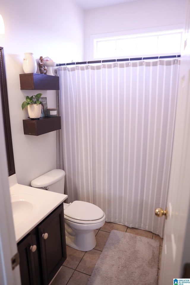 bathroom with tile patterned floors, toilet, a shower with shower curtain, and vanity