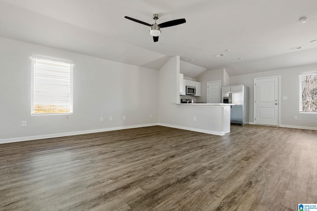 unfurnished living room featuring lofted ceiling, dark wood-type flooring, and ceiling fan