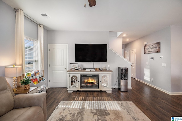 living room with dark hardwood / wood-style flooring and ceiling fan